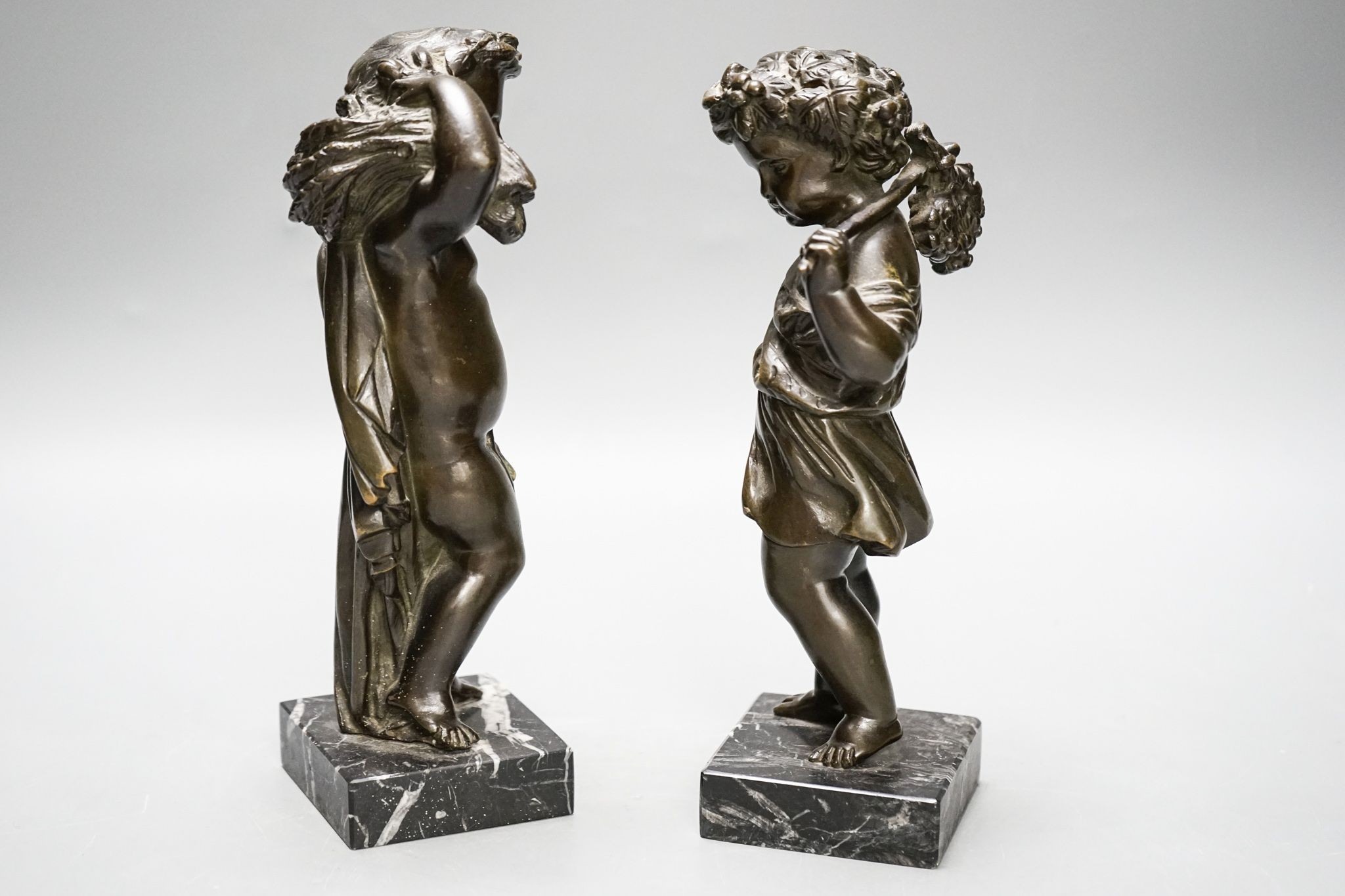 A pair of Victorian bronze putti emblematic of Summer and Autumn, on marble bases 22cm